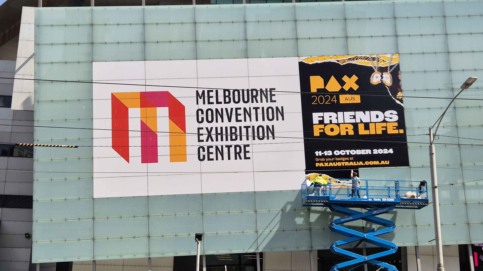 Banner for PAX Aus 2024 being hung on the Melbourne Convention Center