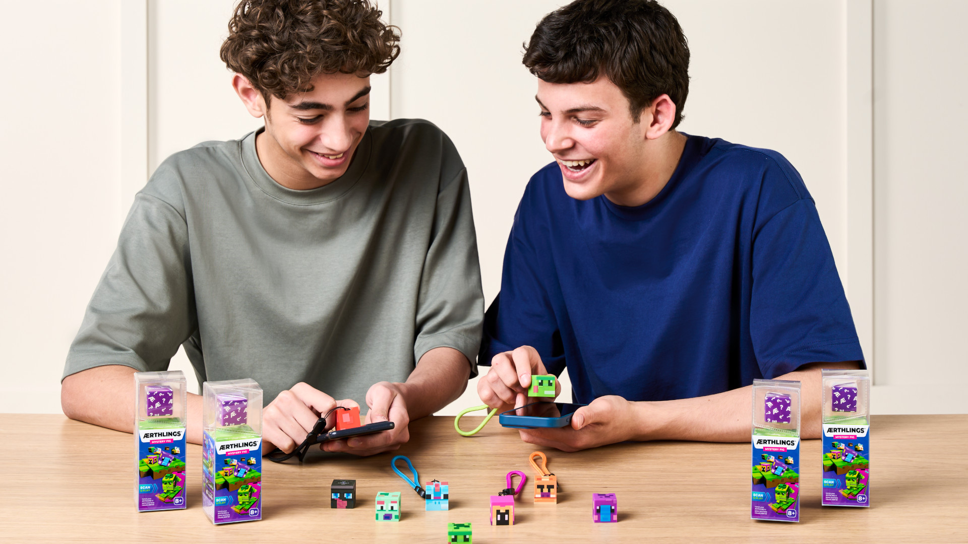 Two children playing with the physical ÆRTHLINGS figures